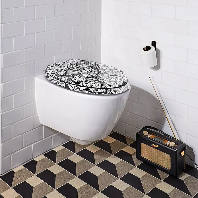 Tohaa Design WC-Sitz Interrelated - Gabe Weis -  - Weißes wandhängendes WC mit schwarz-weiß gemustertem Sitz, daneben ein schwarzes Vintage-Radio auf geometrischem Boden.