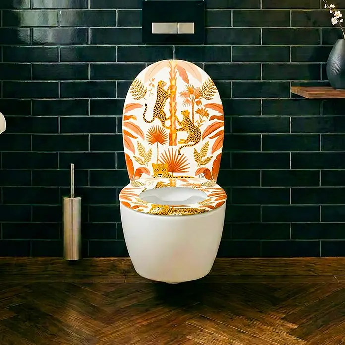 Wodea WC-Sitz   -  Léopard -  - Weiße Toilette mit dekorativem Sitz und Deckel, Dschungelmuster aus Leoparden und tropischen Blättern in Orange/Gelb, im Badezimmer.