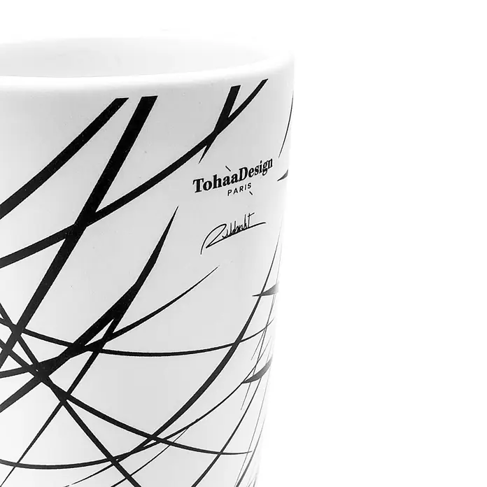 Tohaa Design Zahnputzbecher Arrow - L. Rubbrecht -  - Weißer Keramikbecher mit schwarzen abstrakten Linien und dem TohaaDesign PARIS Logo mit Unterschrift.