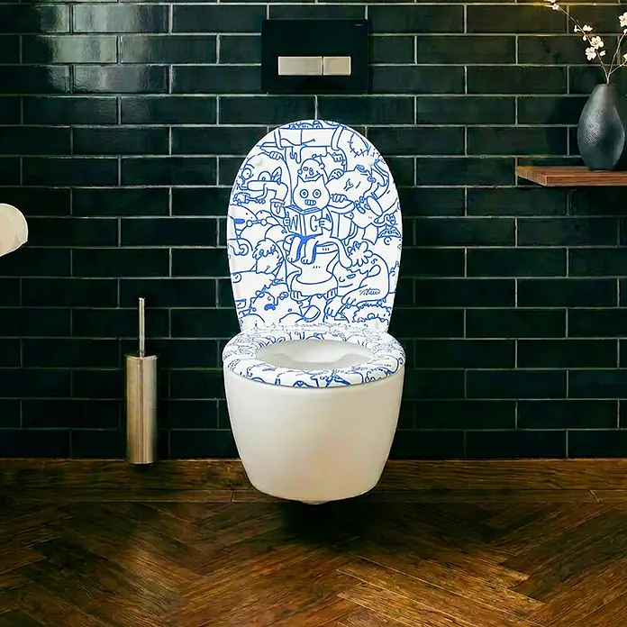 Wodea WC-Sitz   -  Cat -  - Toilette mit weißem Sitz und Deckel mit blauem Doodle-Muster, vor dunklen Fliesenwänden.