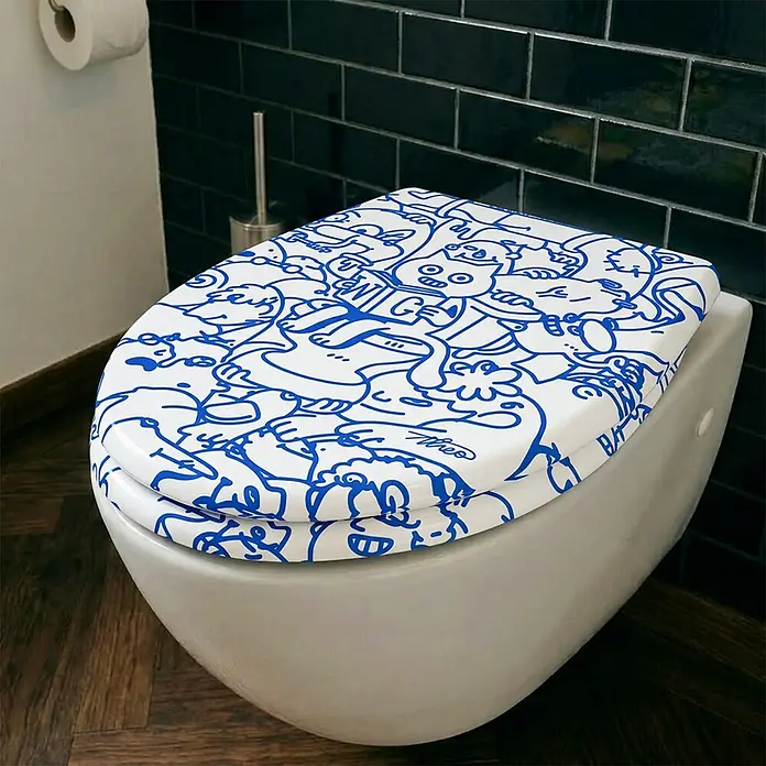 Wodea WC-Sitz   -  Cat -  - Weiße Toilettenbrille mit verspieltem blauen Doodle-Muster, auf einer modernen Toilette im Badezimmer installiert.