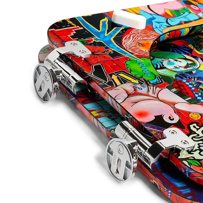 Tohaa Design WC-Sitz Vanity Fair Modern-D - Guive Khosravi -  - Nahaufnahme eines bunten, mit Graffiti-Kunst verzierten Koffers mit verchromten Rollen und Beschlägen.