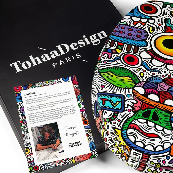TohaaDesign WC-Sitz Crazy Maniac - Skwak -  - Weißer WC-Sitz mit lebhaftem, mehrfarbigem Doodle-Design, präsentiert mit schwarzer Verpackung und Künstlerkarte.