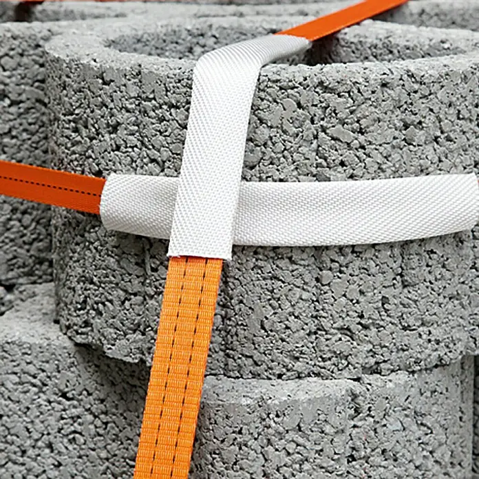 Conacord Schutzschlauch - Länge: 25 cm, Breite: 4 cm, Für Seildurchmesser: 35 mm, 2 Stk. - Betonsteine sind mit orangefarbenen und weißen Gurten fest zusammengebunden und für den Transport gesichert.