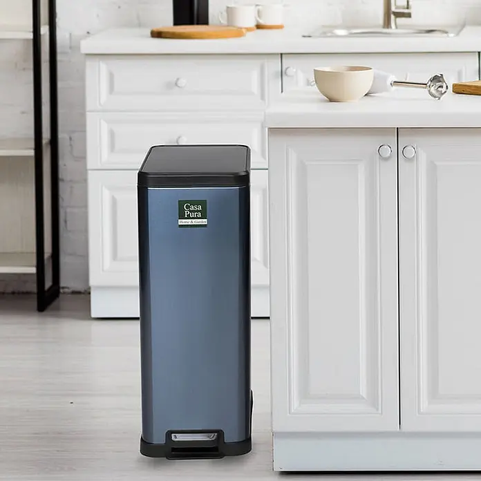 Floordirekt Standard-Mülleimer Zack 15 L Blau - 15 l, Edelstahl, Blau - Rechteckiger, metallisch blauer Küchen-Mülleimer mit schwarzem Deckel und Fußpedal, neben weißen Schränken stehend.