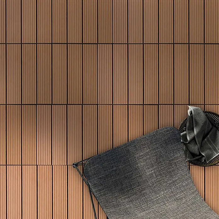 Floordirekt WPC-Klickfliese Royal Hellbraun 30 x 30 cm -  - Braune Holzoptik-Verbundterrassenfliesen auf einer Terrasse, mit teilweise sichtbaren Gartenmöbeln.