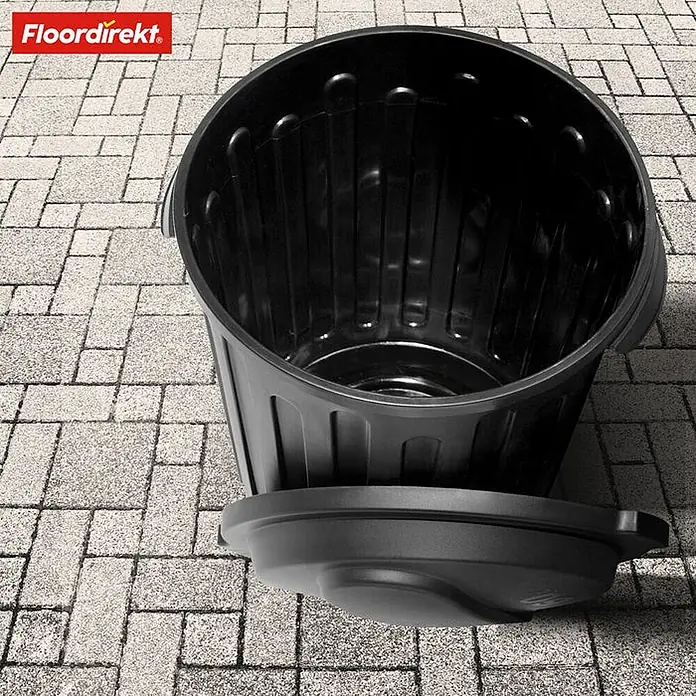 Floordirekt Mülleimer Robin 60L -  - Schwarzer Plastik-Mülleimer mit Deckel auf Pflastersteinen.