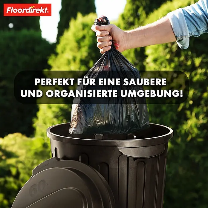 Floordirekt Mülleimer Robin 60L -  - Eine Hand legt einen gefüllten schwarzen Müllsack in eine schwarze Mülltonne im Freien.