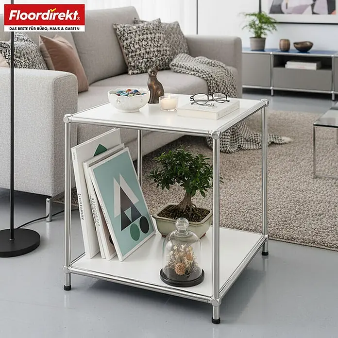 Floordirekt Metallregal Concept Epure MK-012 Weiß 40 x 40 x 46 cm -  - Weißer und silberner Metall-Beistelltisch/Regal in einem Wohnzimmer, mit Büchern und Dekoration, neben einem grauen Sofa.