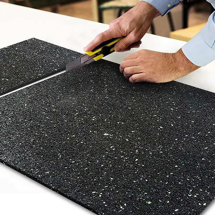 Floordirekt Antivibrationsmatte 60 x 60 x 1 cm -  - Schwarze gesprenkelte Matte wird mit einem Teppichmesser geschnitten.