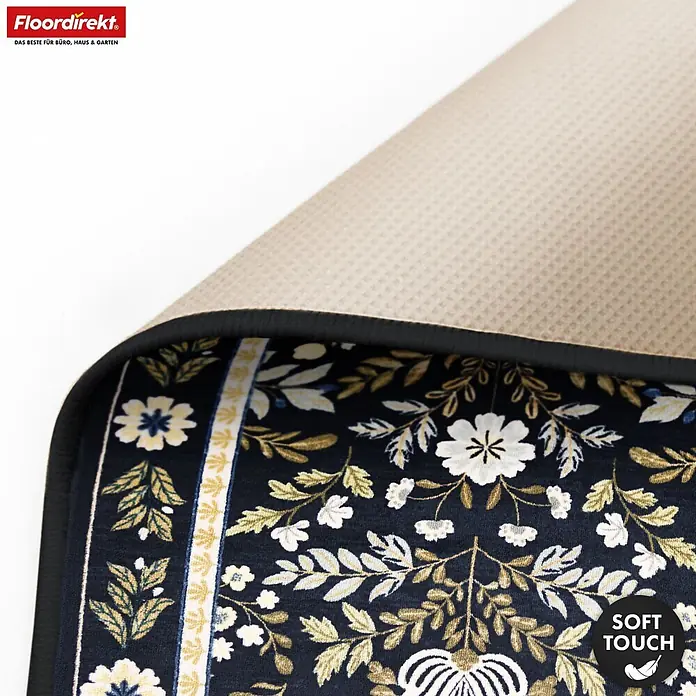 Floordirekt Kurzflorteppich Aristo 160 x 230 cm - Schwarz - Dunkelblauer Teppich mit weiß-goldenem Blumenmuster, zeigt seine beige rutschfeste Rückseite und die "Soft Touch"-Eigenschaft.