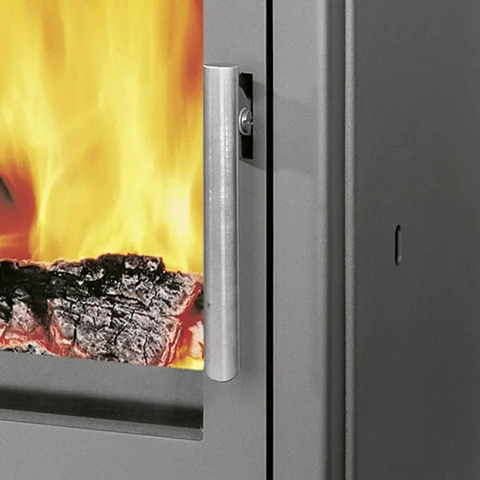 Justus Kaminofen Austin 5 - 5 kW, Raumheizvermögen: 88 m³, Material Verkleidung: Speckstein, Schwarz/Speckstein - Nahaufnahme eines Kaminofens mit sichtbarem Feuer und einem silbernen Griff.