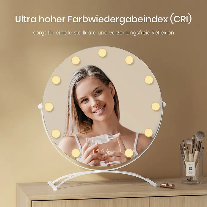 Runder Kosmetikspiegel CM11 -  - Ein runder LED-Schminkspiegel mit weißem Rahmen und Standfuß, der eine lächelnde Frau beim Auftragen von Gesichtsserum reflektiert. Er steht auf einer Holzkommode.