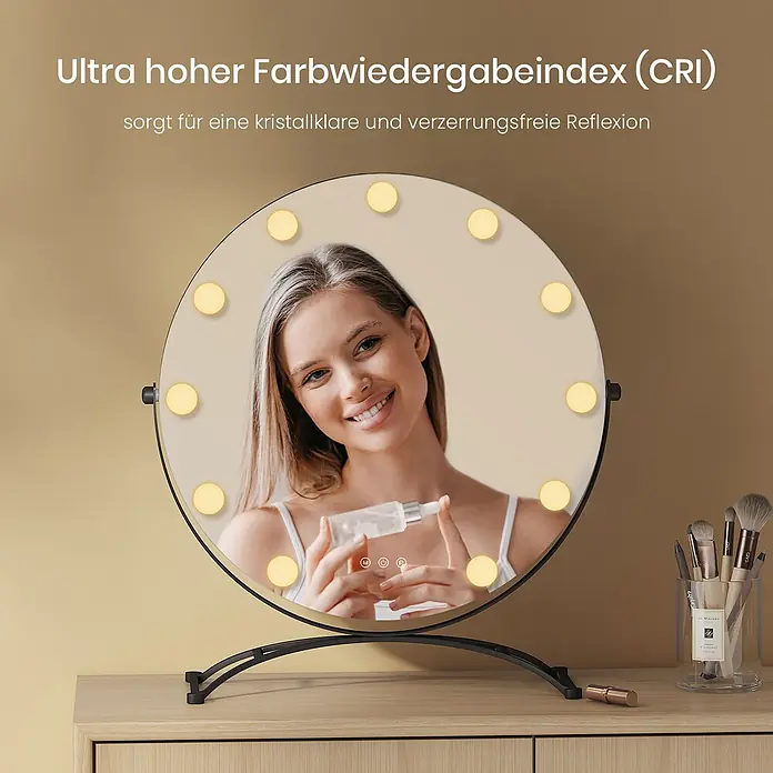 Emke Kosmetikspiegel CM11 - Rund, Schwarz - Runder LED-Schminkspiegel mit schwarzem Standfuß auf Holzkommode, spiegelt eine Frau beim Auftragen von Serum. Daneben sind Make-up-Pinsel.