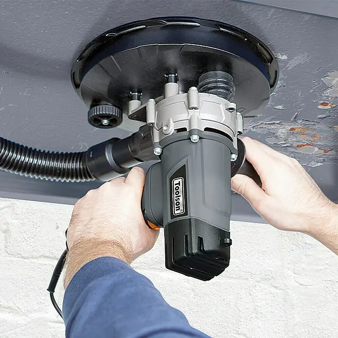 Toolson Wand- & Deckenschleifer DWS 225 DC - 1.200 W, Durchmesser Schleifteller: 215 mm - Eine Person benutzt einen Toolson Deckenschleifer, um eine Decke zu bearbeiten.