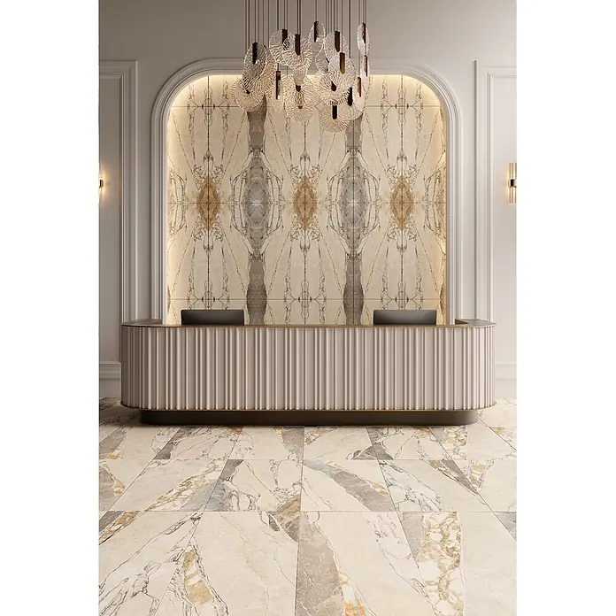 Feinsteinzeugfliese TEKTONIS MARBLE – 60 x 120 cm, Marmoroptik, Mat -  - Eleganter beiger gerillter Empfangstresen mit Goldleiste und dunklem Sockel in einer opulenten Lobby.