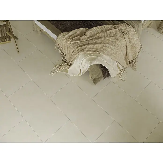 Feinsteinzeugfliese ARK IVORY – 60 x 120 cm, Betonoptik, Mat -  - Helle, beigefarbene Bodenfliesen diagonal in einem Schlafzimmer verlegt, neben einem Bett.