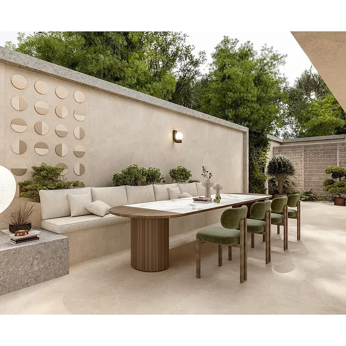 Feinsteinzeugfliese BURGOGNA STONE – 120 x 120 cm, Steinoptik, Mat -  - Großformatige beigefarbene Fliesen auf einer Außenterrasse mit dekorativen beigen runden Wandfliesen und üppigem Grün.