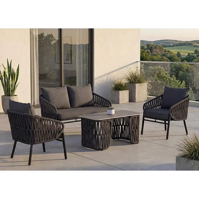 Mendler Gartengarnitur HWC-P90 Stoff/Textil - anthrazit -  - Dunkelgraues Outdoor-Sofa, zwei Sessel und Couchtisch mit passenden Kissen auf einer Terrasse als gemütliche Sitzgruppe.