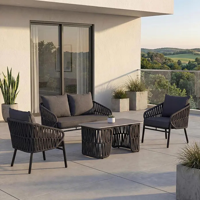 Mendler Gartengarnitur HWC-P90 Stoff/Textil - anthrazit -  - Modernes Outdoor-Loungeset aus dunkelgrauem Geflecht mit Sofa, zwei Sesseln und Couchtisch auf einem Balkon.