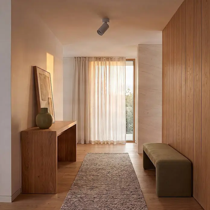 Arcchio Wandstrahler innen, Deckenstrahler 350° drehbar, 90° schwenkbar -  - Moderner Eingangsbereich mit hellem Holzkonsolentisch, grüner Bank und transparenten Vorhängen.