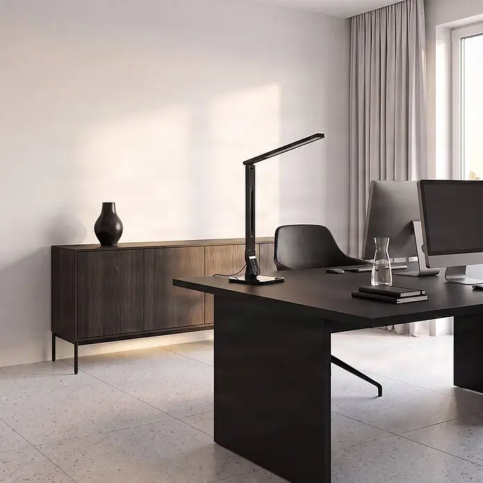 Lindby LED Schreibtischlampe in schwarz, dimmbar Tischlampe -  - Moderne schwarze Schreibtischlampe auf einem dunklen Bürotisch, die verstellbare Arbeitsbeleuchtung für einen produktiven Arbeitsplatz bietet.