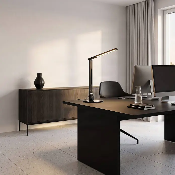 Lindby LED Schreibtischlampe in schwarz, dimmbar Tischlampe -  - Eine elegante, schwarze LED-Schreibtischlampe beleuchtet einen modernen Bürotisch.