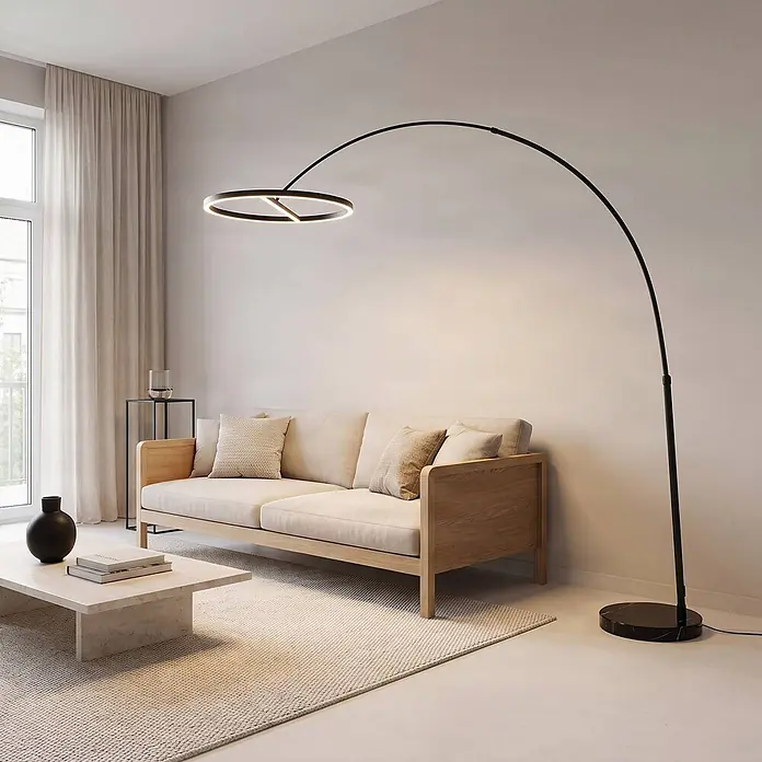 Lucande LED Stehlampe in schwarz, Bogenlampe Wohnzimmer -  - Große schwarze Bogenstehleuchte mit rundem LED-Lichtring und schwarzem Marmorfuß, beleuchtet ein modernes Wohnzimmersofa.