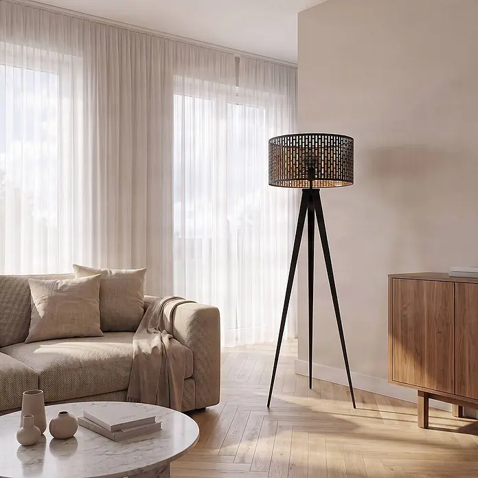 Lindby Stehlampe Dreibein schwarz gold mit Fußschalter, ohne Leuchtmittel -  - Schwarze Tripod-Stehlampe mit gemustertem Metallschirm in einem modernen Wohnzimmer.