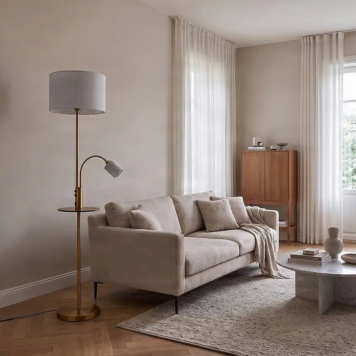 Lindby Stehlampe Wohnzimmer in bronze, creme, Stehleuchte -  - Gemütliches Wohnzimmer mit hellbeigem Stoffsofa, Messing-Stehlampe mit Leselicht und rundem Couchtisch aus weißem Marmor.