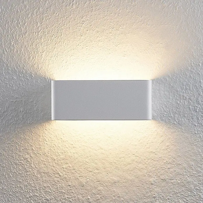 Arcchio LED Wandleuchte innen in weiß, Wandlampe -  - Rechteckige graue Wandleuchte an einer strukturierten Wand, die warmes Licht nach oben und unten wirft.