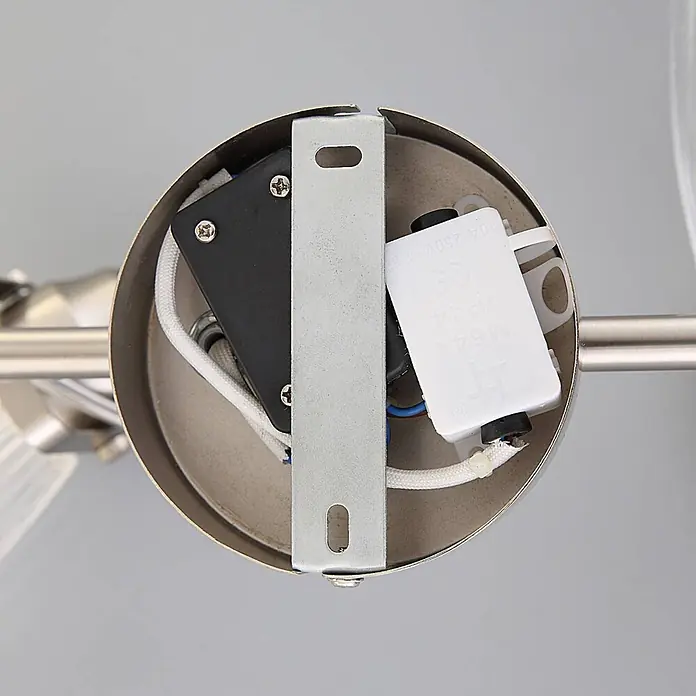 Lindby Wandleuchte innen in nickel matt, transparent, Wandlampe -  - Innenansicht der gebürsteten Metallbasis einer Leuchte mit Halterung und Elektroteilen.