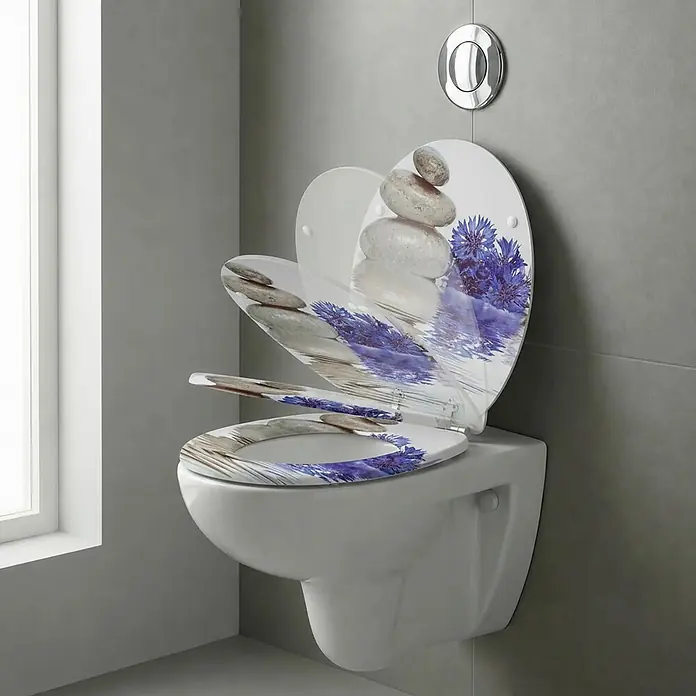 SAINOS WC-Sitz aus MDF, Blumen Zen Design, Universal-O-Form, Absenkautomatik - Soft-Close - Weißer Toilettensitz mit dekorativem Aufdruck aus gestapelten Steinen und blauen Blumen, offen auf einer wandhängenden Toilette.