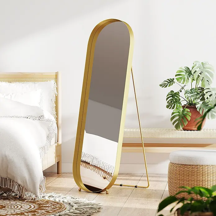 HOMCOM-Ganzkörperspiegel-50L x 6B x 160H cm-Gold Oval -  - Ein hoher, ovaler Ganzkörperspiegel mit goldenem Rahmen steht in einem hellen Schlafzimmer.