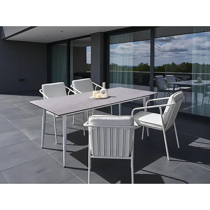 Esstisch TOLENTINO in Weiß/Beige - (W) 90 x (H) 75 x - L - Moderne Outdoor-Essgruppe mit grauem Tisch und weißen Stühlen mit Kissen auf einer großen Terrasse.