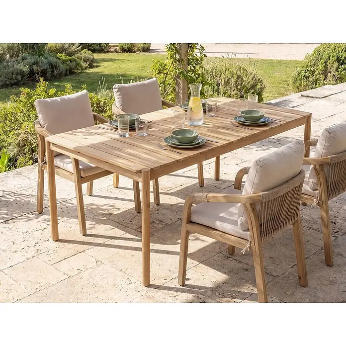 Esstisch MANADO in Braun - (W) 100 x (H) 76 x - L - Outdoor-Essgruppe mit rechteckigem Holztisch und Stühlen mit hellen Kissen und geflochtenen Rückenlehnen auf einer Terrasse.