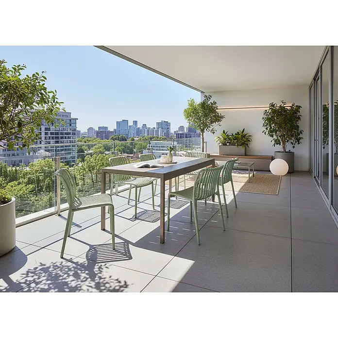 Esstisch BARTICA in Braun - (W) 84 x (H) 76 x - L - Hellgrüne Outdoor-Stühle mit Lattenrost und passender Tisch auf modernem Balkon mit Stadtblick, für Mahlzeiten bereit.