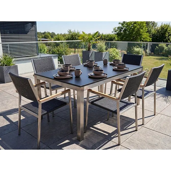 Esstisch GROSSETO in Schwarz/Silber - (W) 90 x (H) 76 x - L - Gartentisch mit Stühlen: dunkle Platte, Metallrahmen, dunkle Geflechtsitze, Holzarmlehnen. Auf Terrasse mit Geschirr arrangiert.