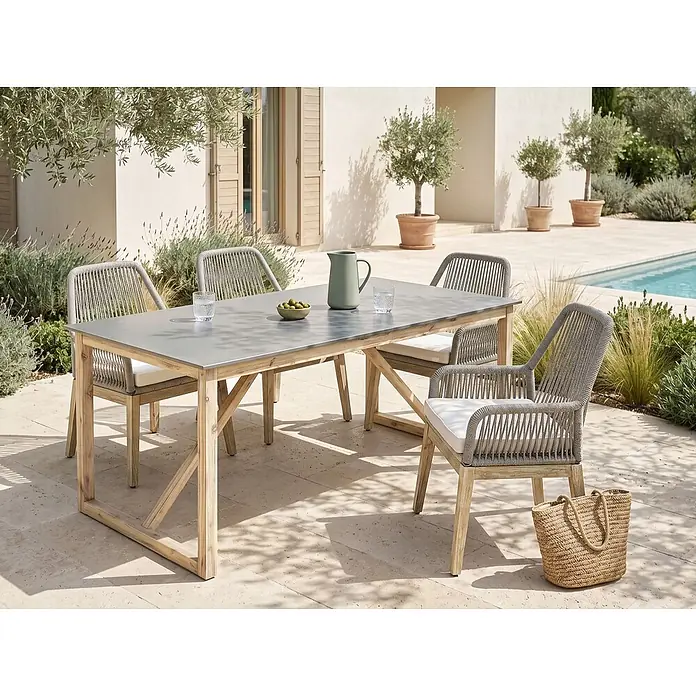Esstisch NOTTERI in Grau/Braun - (W) 90 x (H) 75 x - L - Outdoor-Essgruppe: ein heller Holztisch mit grauer Platte und vier Stühle mit grauen Seilgeflecht-Rücken/-Armlehnen und weißen Kissen auf einer Terrasse.