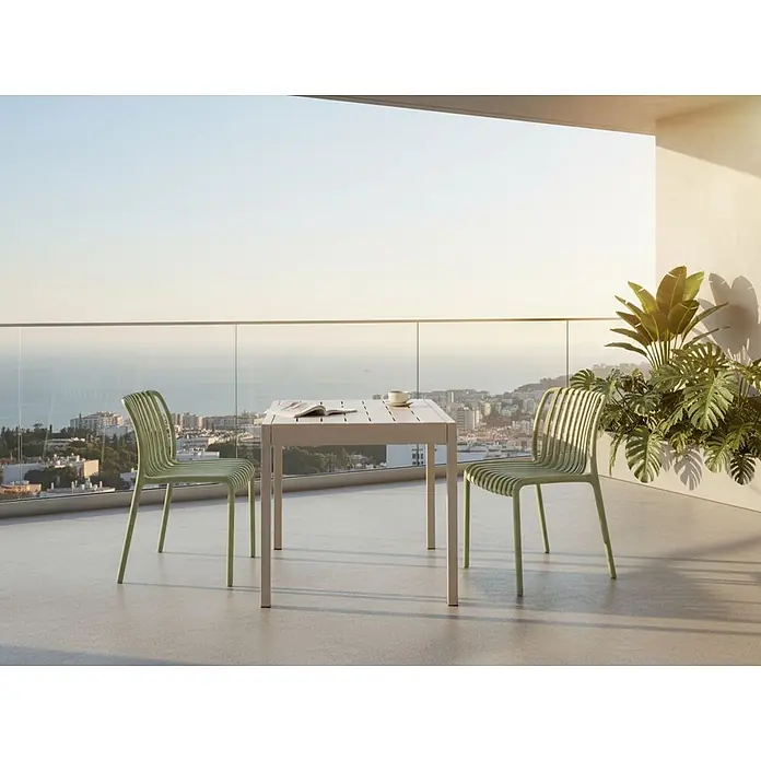Esstisch BARTICA in Beige - (W) 84 x (H) 77 x - L - Zwei hellgrüne Lamellenstühle und ein weißer Lamellentisch auf einem sonnigen Balkon.