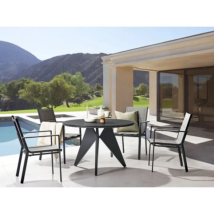 5-tlg Gartentisch Set OLMETTO/BUSSETO in Schwarz/Grau/Braun -  - Dunkles Outdoor-Essset: runder Tisch mit eckigem Untergestell und vier Stühlen mit hellgrauer Netzsitzfläche auf einer Terrasse am Pool.