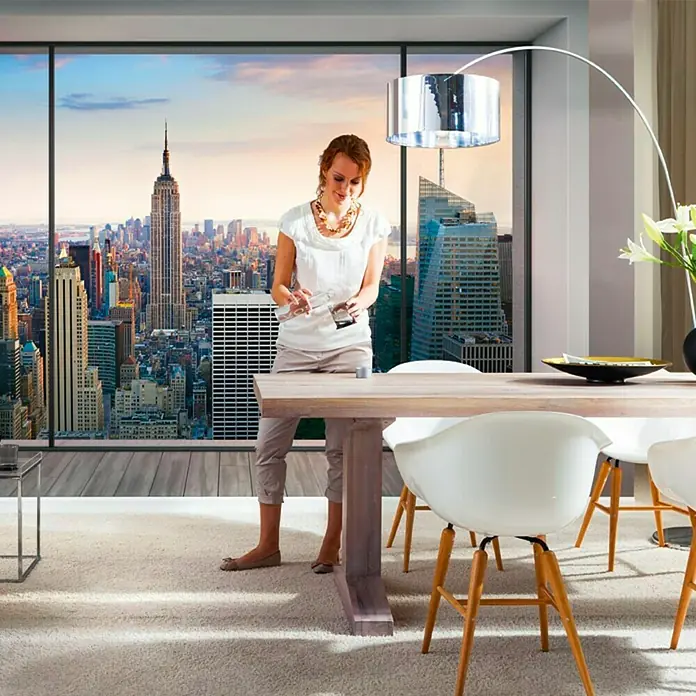 Komar Fototapete Penthouse - 8 -tlg., B x H: 368 x 254 cm, Papier - Esszimmer mit Holztisch, weißen Stühlen und einer Frau vor einem Fenster mit Stadtblick. Die Lampe ist ein Blickfang.