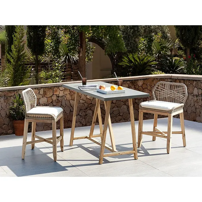 3-tlg Bistro Set TALAMONE in Braun/Grau/Beige -  - Outdoor-Bartisch-Set mit grauer Tischplatte, hellen Holzbeinen und zwei passenden Barhockern mit geflochtenen Rückenlehnen und weißen Kissen auf einer Terrasse.