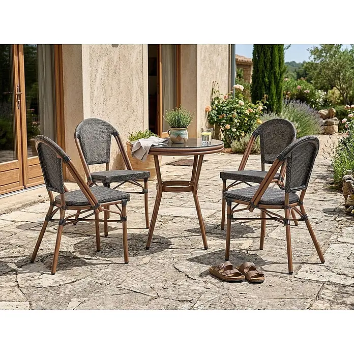 5-tlg Gartentisch Set RIFREDDO in Grau/Braun -  - Eine Garten-Essgruppe mit rundem Glastisch und vier Stühlen, mit dunklen Geflechtsitzen und hellbraunen Rahmen, auf einer Terrasse.