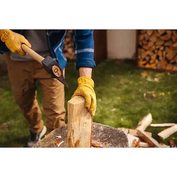 Hultafors KVILLINGE Spaltaxt -  - Person in gelben Handschuhen spaltet Holz mit einer Axt.