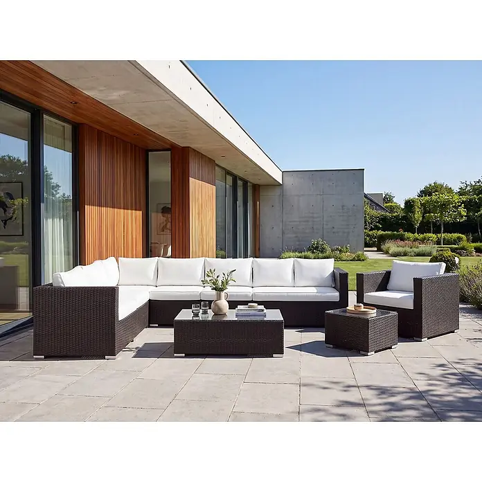 8-tlg Lounge Set XXL in Braun/Weiß rechtsseitig -  - Dunkelbraune Polyrattan-Gartenmöbel mit weißen Kissen: Ecksofa, Sessel und Couchtisch, auf einer Außenterrasse angeordnet.