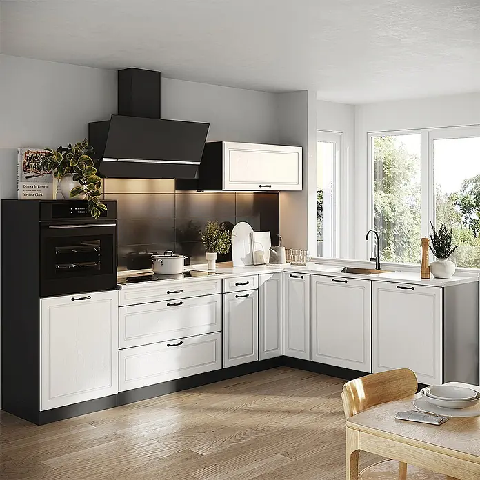 Eckküche R-Line 287 cm Weiß Landhaus Art.-Nr. 68203 -  - L-förmige Küche mit weißen Schrankfronten im Shaker-Stil, schwarzen Griffen, Einbaubackofen, Induktionskochfeld und schwarzer Dunstabzugshaube.