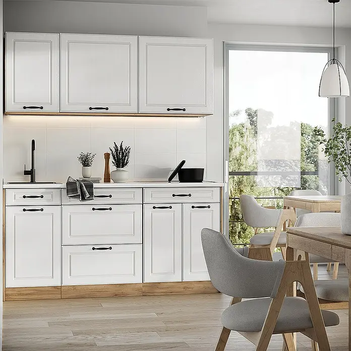 Singleküche R-Line 160 cm Weiß Landhaus Art.-Nr. 67737 -  - Weiße Küchenschränke mit schwarzen Griffen und Holzdetails, in einer modernen Küche neben einem Essbereich.