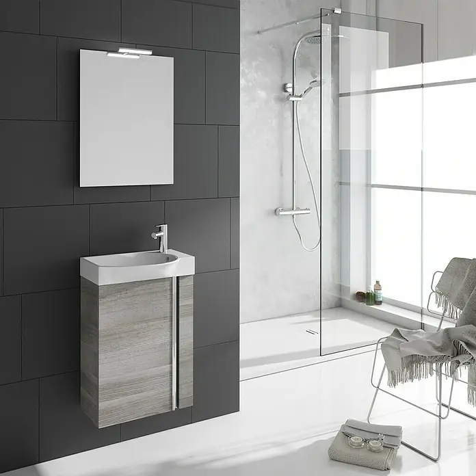 Riva Conjunto de mueble de baño Elegance - Ancho total del mueble de baño: 45,2 cm, Gris plata, Mate - Interior de baño con un moderno mueble de lavabo con aspecto de madera, un espejo y una ducha a ras de suelo.