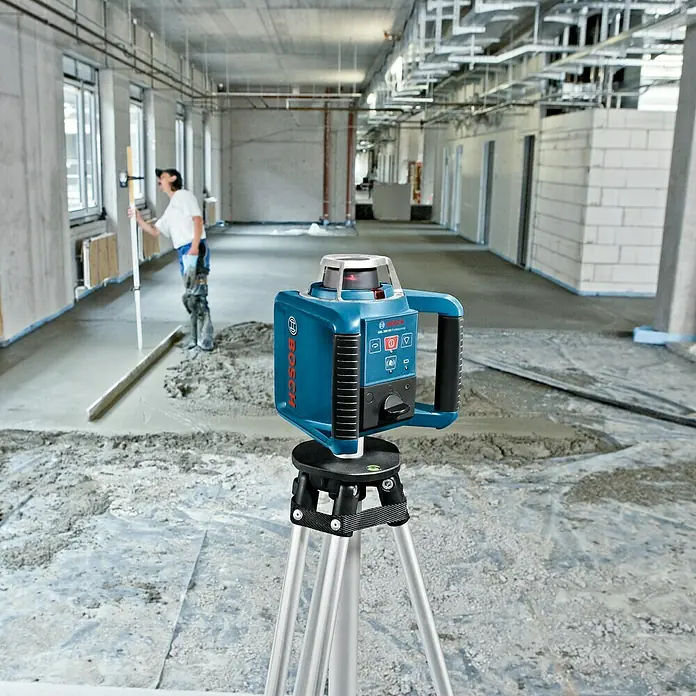 Bosch Professional Rotationslaser GRL 300 HV - Arbeitsbereich: Ø 60 m (ohne Empfänger), 10 -tlg. - Das Bosch GRL 300 HV Rotationslaser-Nivelliergerät auf einem Stativ in einer Baustelle.